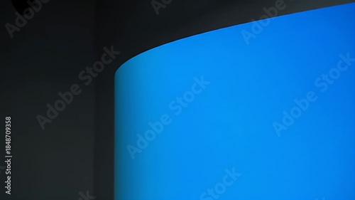 Smooth Curved Green Screen Background With Dark Wall Corner And Subtle Pixels At Top Edge