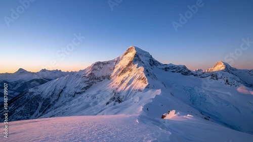 Majestic Snow Covered Mountain Peak Bathed In Golden Hour Sunlight With Deep Blue Sky