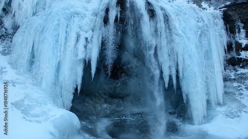 Frozen Waterfall Icicles In Winter Snow Landscape With Flowing Water Blue And White Tones