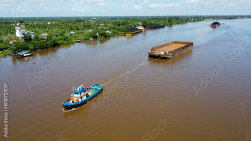 Принти на полотні Aerial view of a tugboat pulling a barge filled with coal in the waters of South