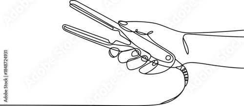 Hand holding hair straightening iron