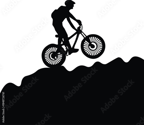 Silhouette of mountain biker riding uphill on a rough terrain