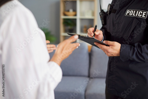 Quadro em tela Close-up of a detective or police officer completing a crime report during interview with a victim captures the essence of a burglary investigation