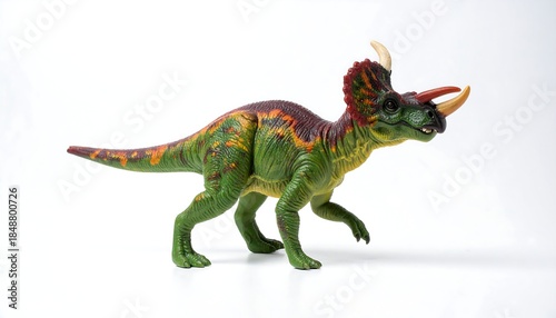 Triceratops toy, green and maroon, stands against a white backdrop, facing right