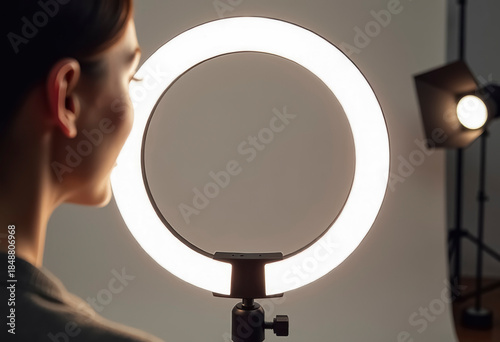 The LED ring light is on, and the model's face is in the foreground, blurred