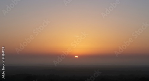 Orange and Yellow Sunrise Over Foggy Landscape