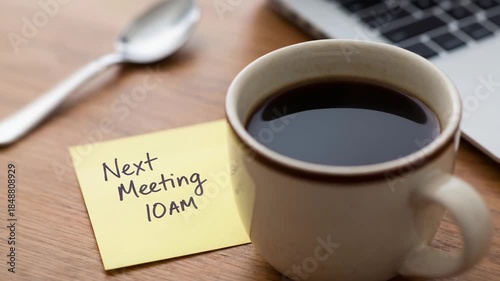 Brainstorming nonprofits starts with warm cup coffee and note reminder about meeting at 10AM on wooden table with laptop for productive collaboration