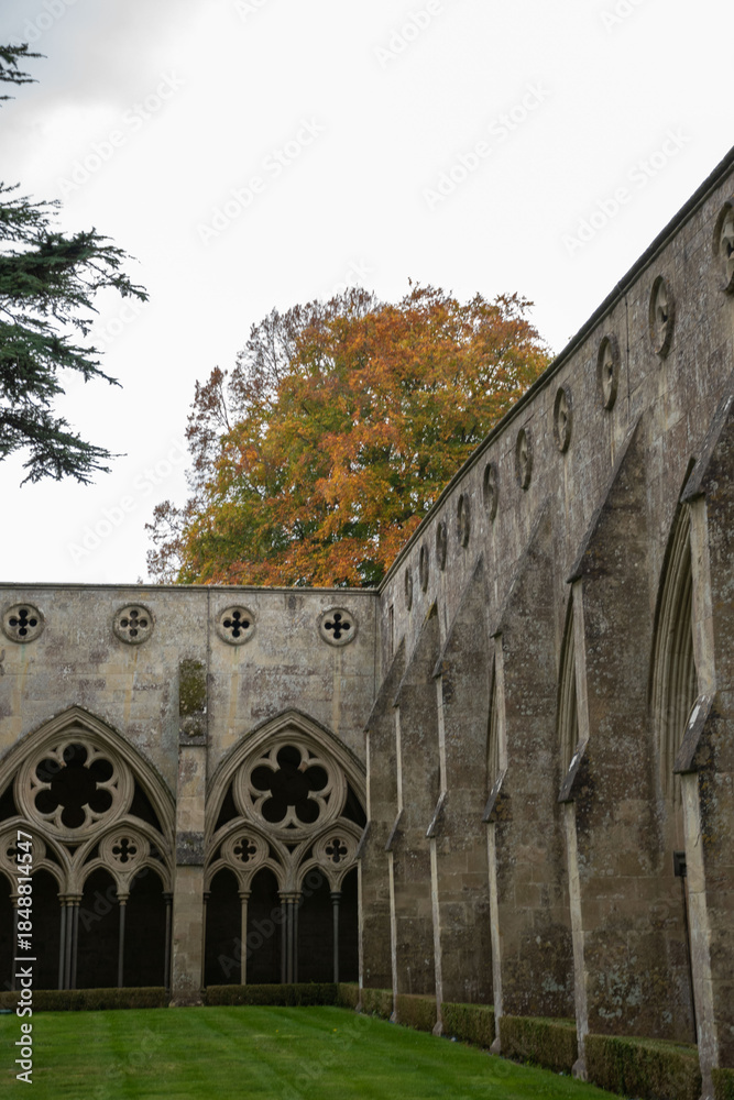 Naklejka premium Salisbury Cathedral's stunning architecture showcasing Early English Gothic design, with intricate arches and beautiful greenery.