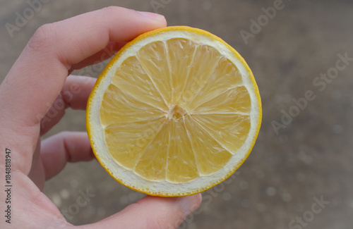 Half a yellow lemon in hand