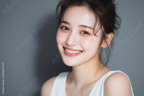 笑顔できらめく綺麗な肌と白い歯を見せる日本人女性美人モデルの接写写真。オーラルケア、スキンケア、コスメ広告用。