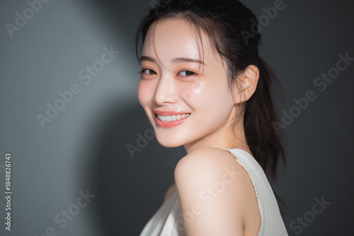 笑顔できらめく綺麗な肌と白い歯を見せる日本人女性美人モデルの接写写真。オーラルケア、スキンケア、コスメ広告用。