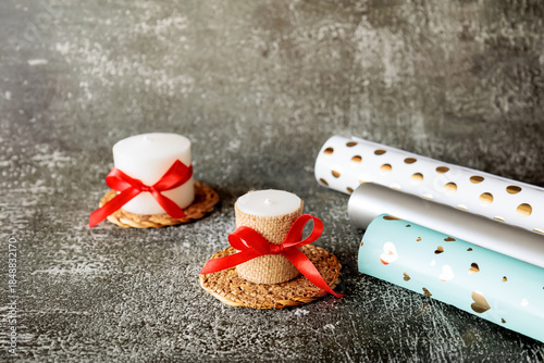 Wallpaper Mural Set of handmade white candles decorated with ribbon and burlap, with rolls of wrapping paper on dark textured background. Holiday or romantic gift idea in cozy minimal style Torontodigital.ca