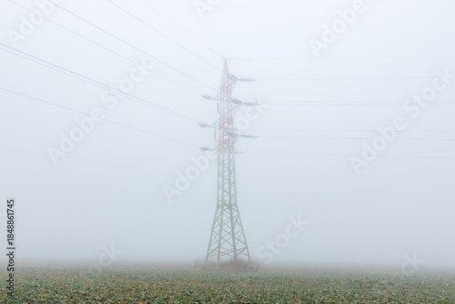 Electric wire tower in fog weather. Minimalism composition, distribution of power, simple industrial background