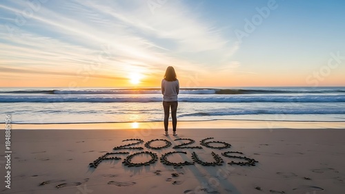 woman standing on beach at sunset with focus written in sand