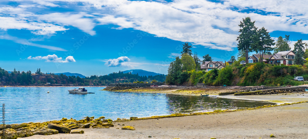 Fototapeta premium Motorboat sailing near chemainus coastline on vancouver island