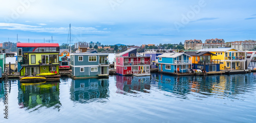 Fotografi Colorful floating homes reflecting in calm water in victoria, british columbia