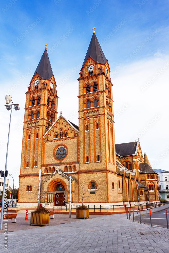 Fototapeta premium nyiregyhaza, eger, hungary - 07 dec 2014: catholic co-cathedral of our lady of hungary and fountain on kossuth square. beautiful urban landscape of nyiregyhaza before christmas under blue sky