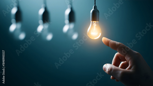 Hand touching glowing light bulb finding inspiration solution