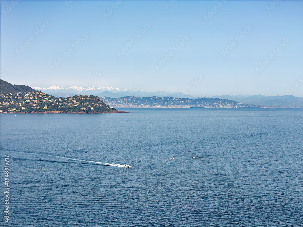 Obraz premium Cliffs on the Cote d'Azur, French Riviera, overlooking Cannes, snow-capped mountains in the background, Drone photo