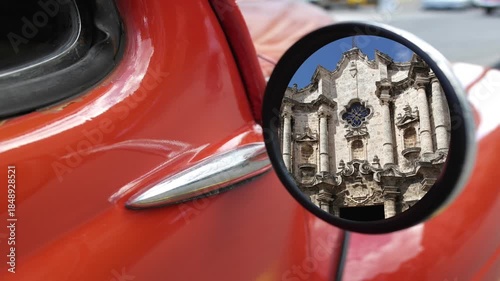 Havana Cathedral located in the Plaza de la Catedral . Old Havana, Havana, Cuba.. Reflected in the mirror of a classic 1950's car 