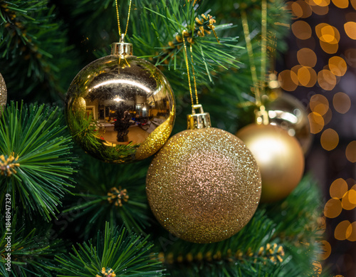 A close-up view of gold Christmas ornaments hanging on a green-needled tree. Ai