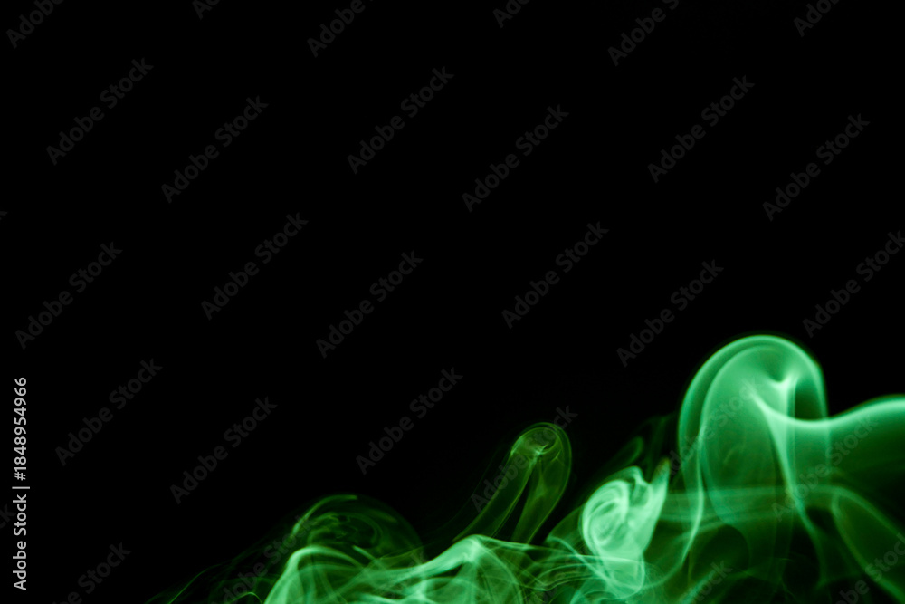 Fototapeta premium Abstract green smoke rising against a dark backdrop, creating an ethereal and mysterious atmosphere