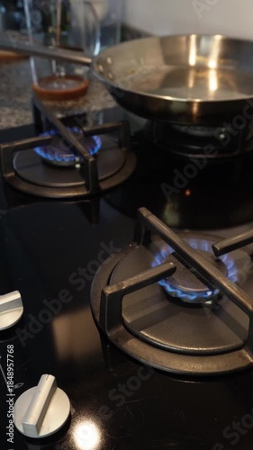 Turning on gas stove burner — close-up vertical video of kitchen cooking preparation. 9:16