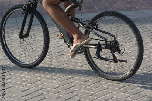 Foto Cyclist riding a bicycle in flip-flops