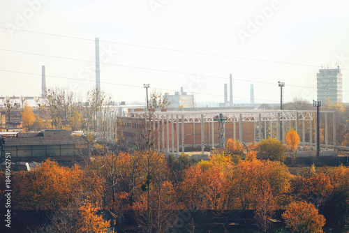 Construction site, factory buildings, chimneys and autumn foliagen in hazy Lviv, Ukraine