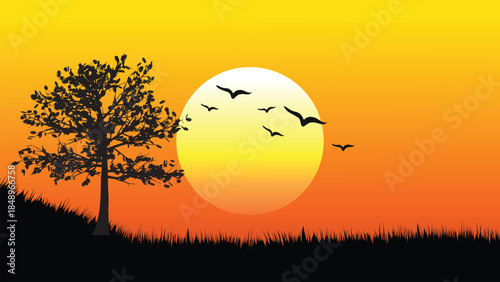 Silhouetted tree and birds at sunset with vibrant orange and yellow sky background