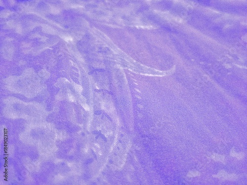 Abstract purple fabric texture with an elegant paisley pattern. Soft lavender textile background with organic flowing shapes and fine weave detail, perfect for fashion or luxury backdrops.