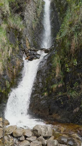 Vertical Shot of a Cascading Mountain Waterfall