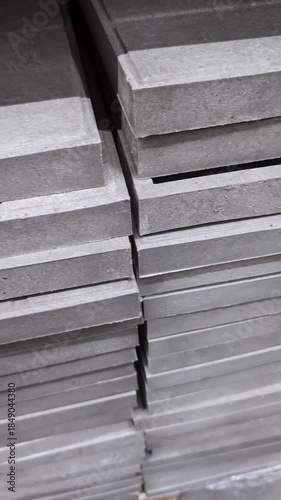 Building materials are stacked in a construction site at noon with workers preparing supplies for the project ahead