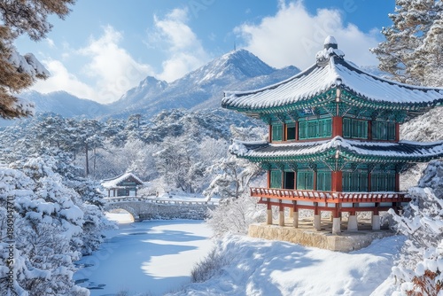 Wallpaper Mural Winter landscape showcasing snow-covered mountains and traditional architecture in Korea with a serene frozen river Torontodigital.ca