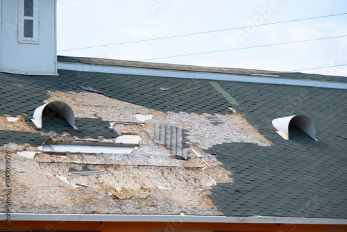 Konstfotografi Damaged roof showing exposed underlayment and missing shingles presenting potent