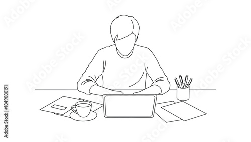 Person focused on laptop working at desk with coffee and papers