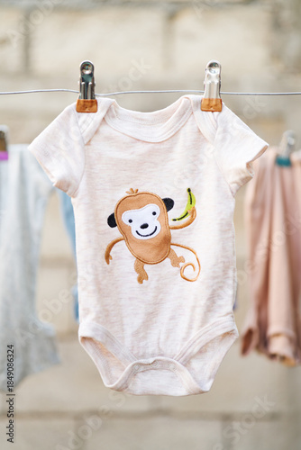 Illustrated baby bodysuit hanging on a clothesline