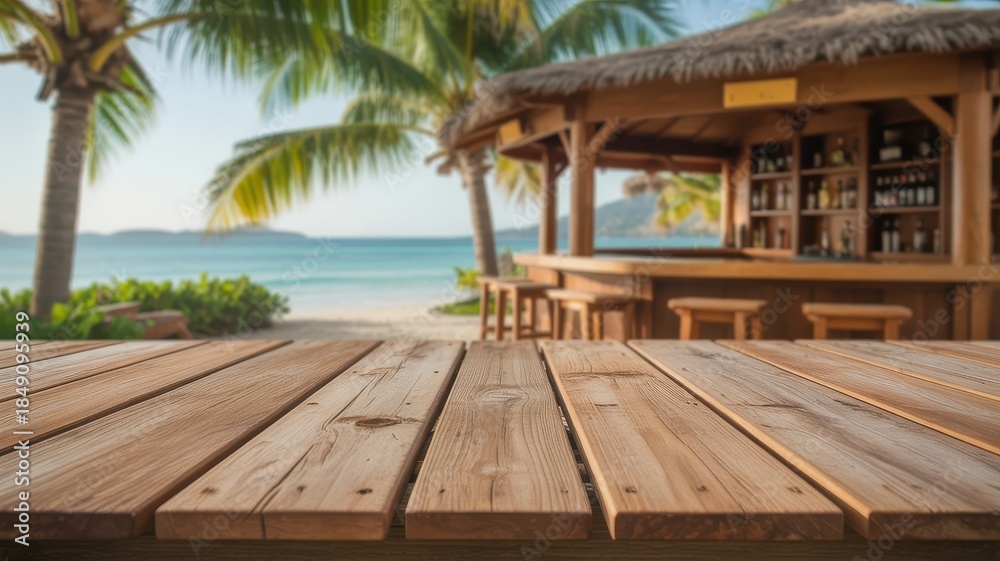 Fototapeta premium Empty wooden table top with blurred tropical beach bar, ocean, and palm trees in the background