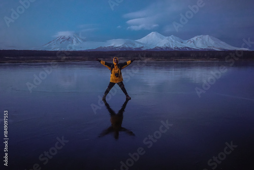 A Man on a Frozen Lake with a View of Kamchatka Volcanoes