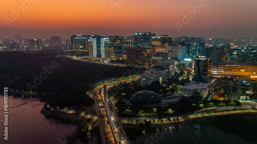 Aerial view of a city skyline with its buildings lit up against the dusk sky, showcasing its vibrant urban landscape, Hyderabad, Telangana, India.