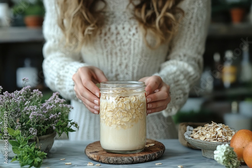 Woman holding jar of oats and bowl of oats.