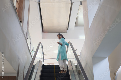 Woman standing on escalator in a modern building