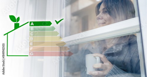 Photos Relaxed woman with a warm mug looks through an energy efficient window featuring