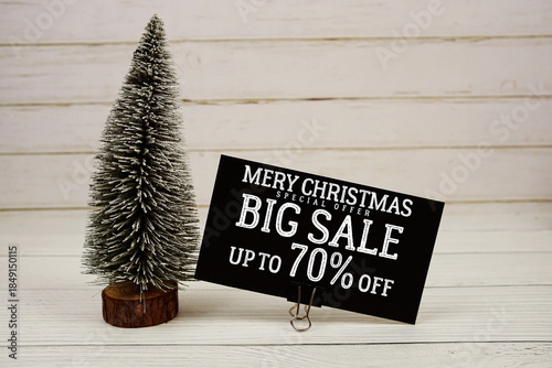 Festive display with small decorative Christmas trees with "Special Offer Merry Christmas Big Sale up to 70% off, Promotion Holiday Sale Event