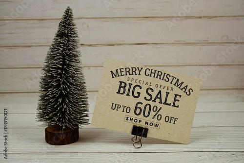 Festive display with small decorative Christmas trees with "Special Offer Merry Christmas Big Sale up to 60% off, Promotion Holiday Sale Event