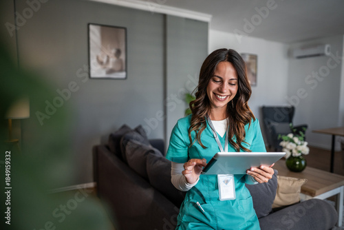 Smiling female nurse using tablet for home care digital health