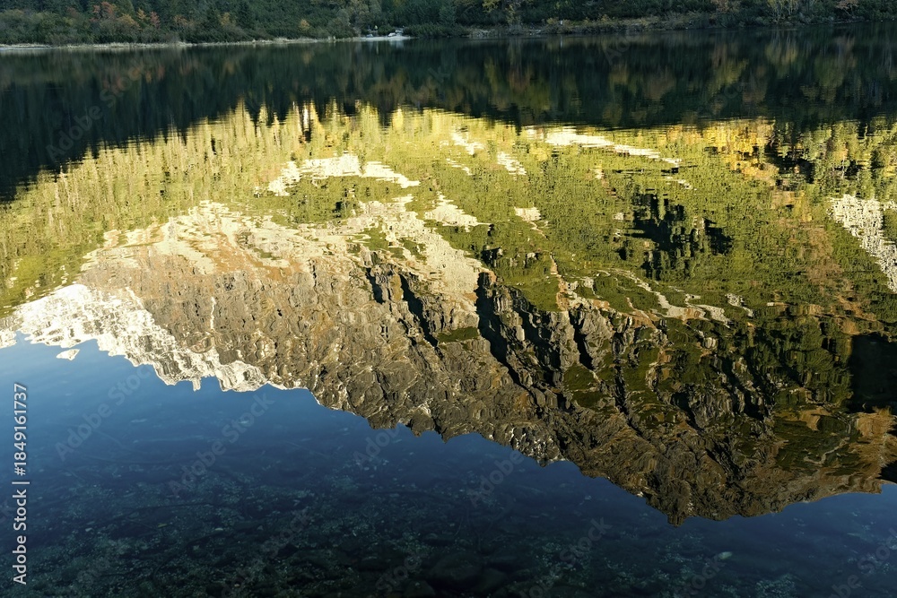 Naklejka premium The reflection of the surrounding mountains in Popradske pleso (Poprad Lake). Vysoke Tatry (High Tatras). Slovakia. Europe.