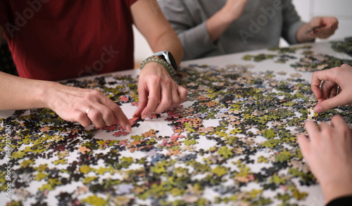 Family Spends Time Together As Female Hands Assemble A Puzzle On A Table