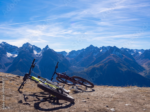 Scuol, Switzerland - October 11th 2025: Two bikes in front of the impressive view from motta naluns biking resort