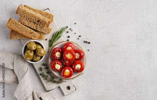 Red cherry peppers stuffed with cheese and olives bread sticks on the table, top view, copy space. Great snack.